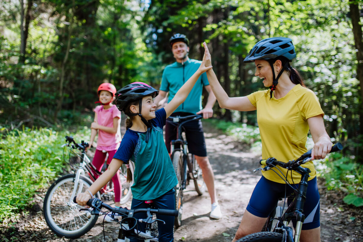 Familie mit Kindern beim Radfahren im Wald