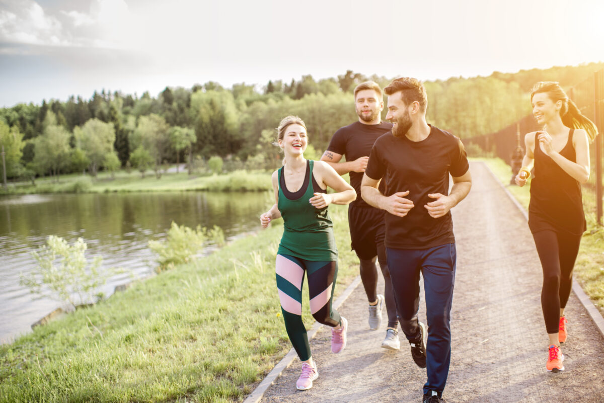 Vier Personen beim Joggen am Wasser