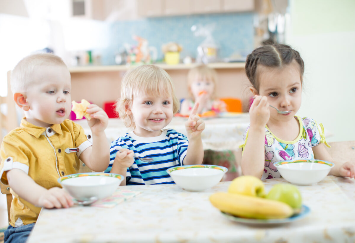 Kinder sitzen am Tisch und essen