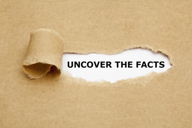Braunes zerrissenes Papier mit Aufdruck: Uncover the facts