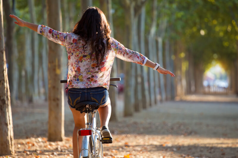 Junge Frau freihändig auf Fahrrad