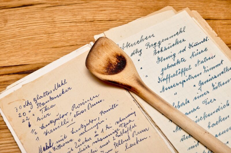 Handschriftliches Kochrezept und Holzkochlöffel