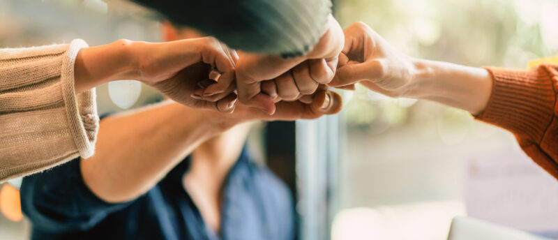 Fäuste von mehreren Personen stoßen zusammen
